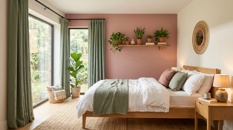 Dusty rose bedroom ideas paired with sage green curtains and natural wood furniture