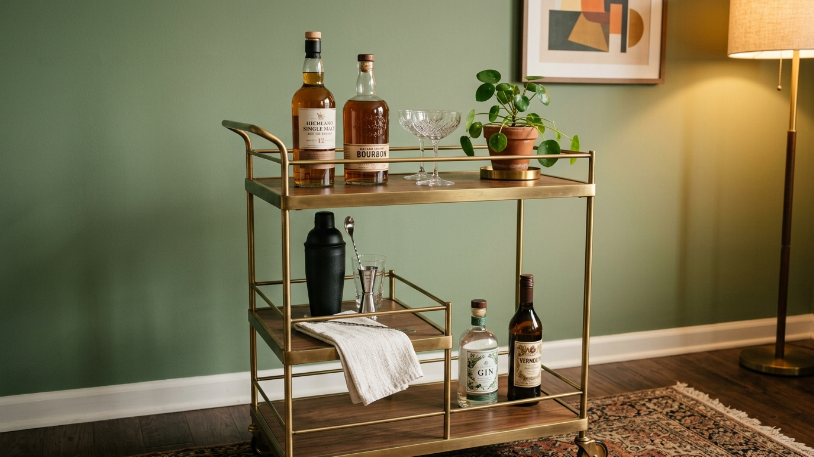 Brass bar cart styled as an anchor piece demonstrating how to style a home bar in a mid-century modern room.